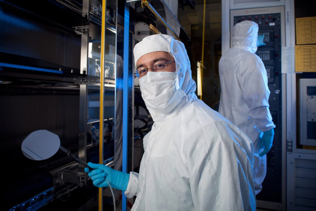 Rogue Valley Microdevices engineer handling a silicon wafer in the cleanroom